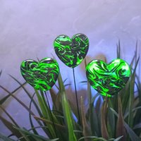 Uranium vasoline glass heart plant pick with black swirls on 5in wire. Use for floral bouquet, plants, jewelry, gifts; handmade by me; 395nm