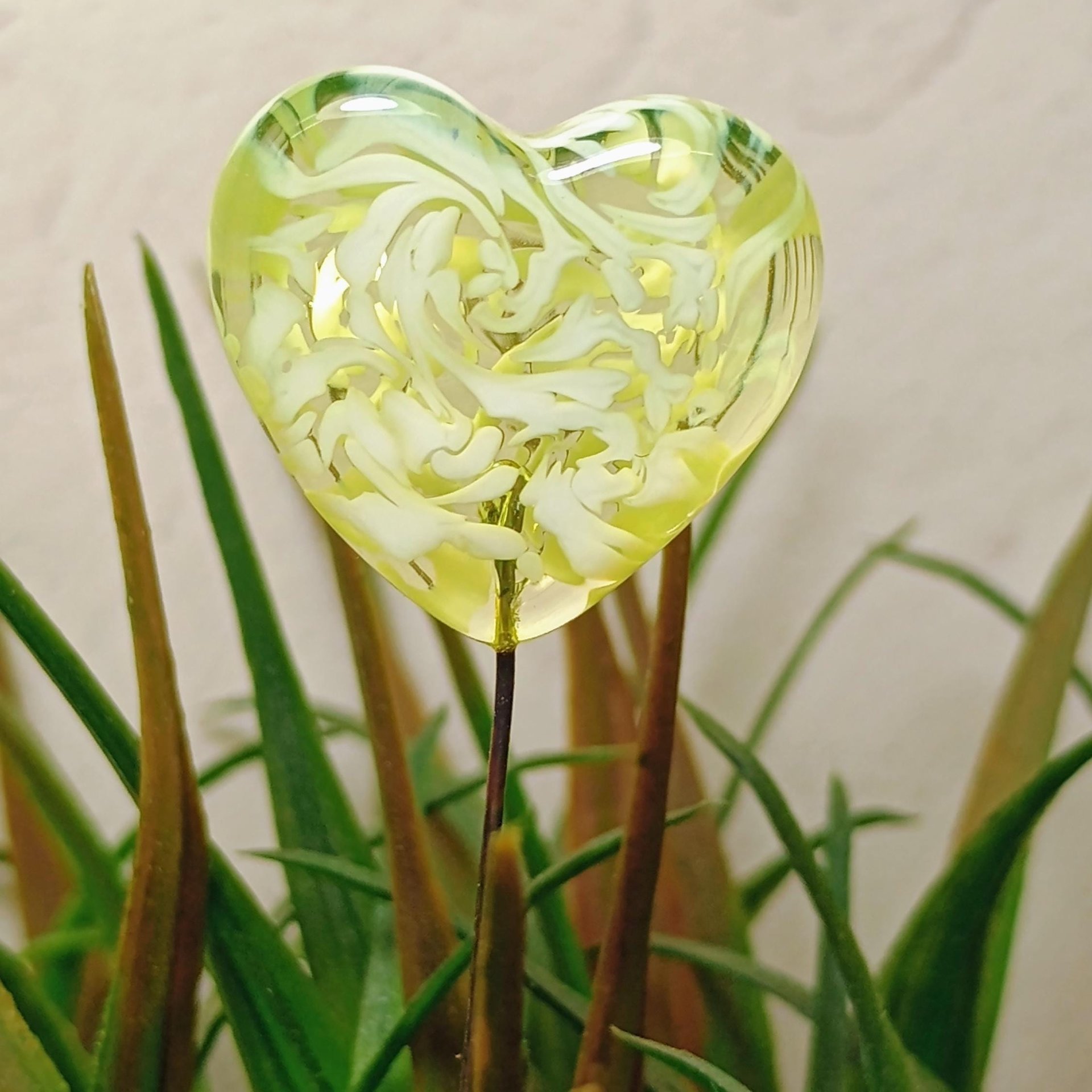 Uranium vasoline glass heart plant pick with white swirls on 5in wire. Use for floral bouquet, plants, jewelry, gifts; handmade by me; 395nm