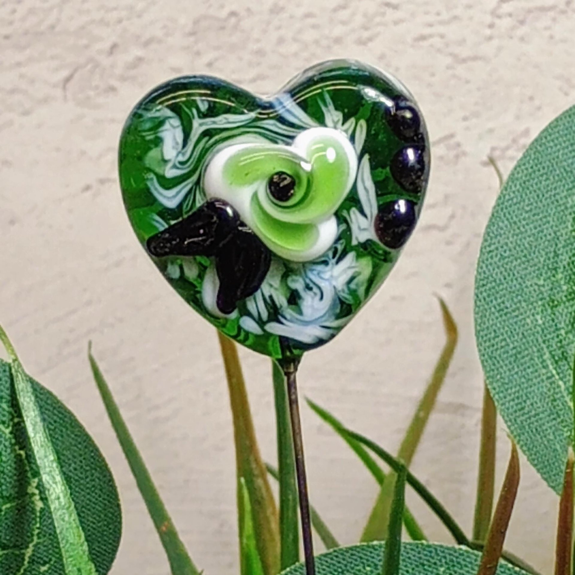 Glass Heart Plant Pick: Green/White with Swirled Flower, 3/4in x 3/4in on 5in wire. Floral bouquet, plants, jewelry, gifts; each unique