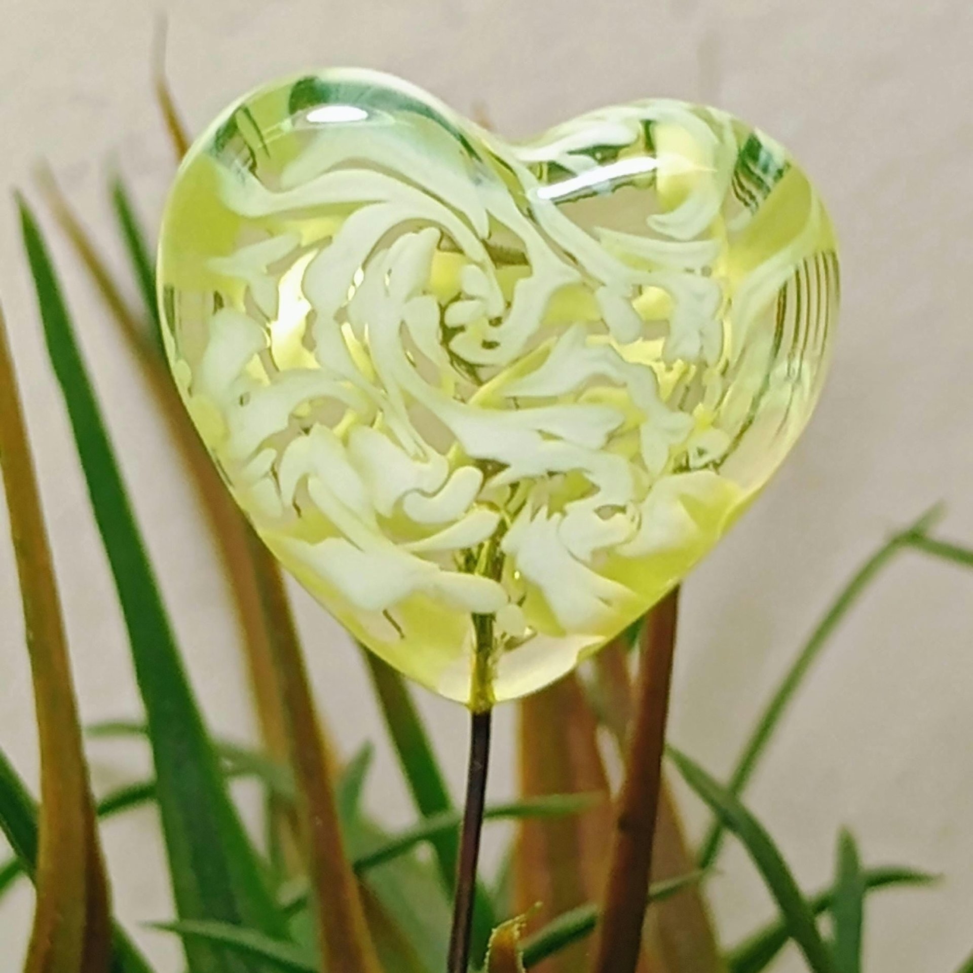 Uranium vasoline glass heart plant pick with white swirls on 5in wire. Use for floral bouquet, plants, jewelry, gifts; handmade by me; 395nm